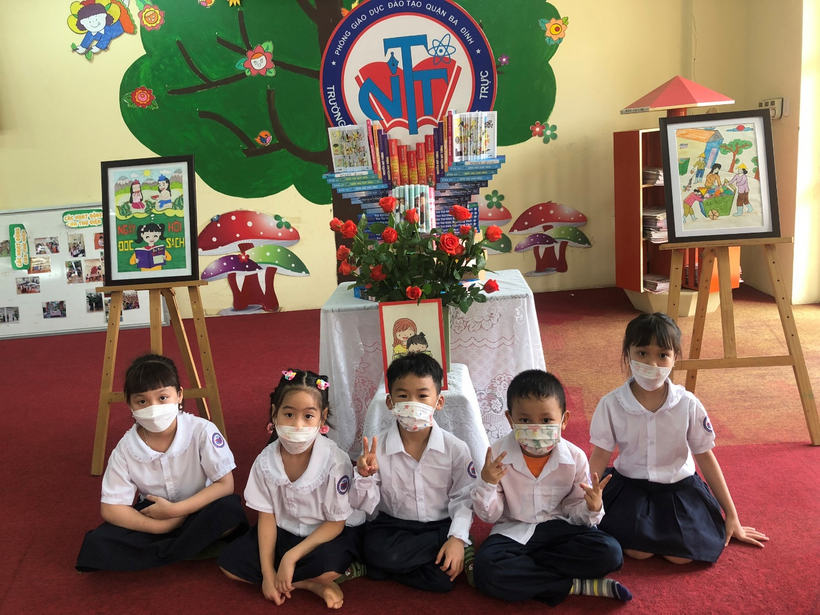 A group of children sitting on the floor in front of a christmas tree
Description automatically generated