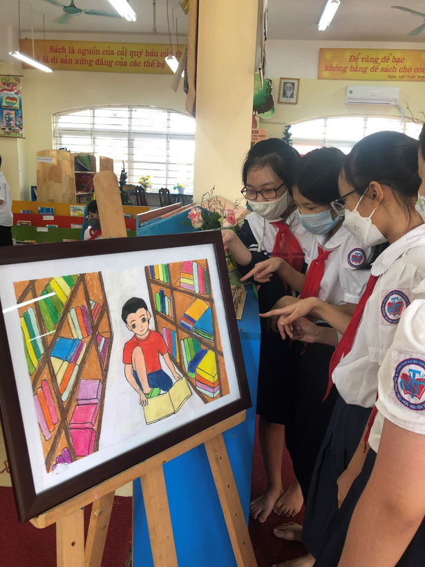 A group of people looking at a picture on a wall
Description automatically generated with low confidence