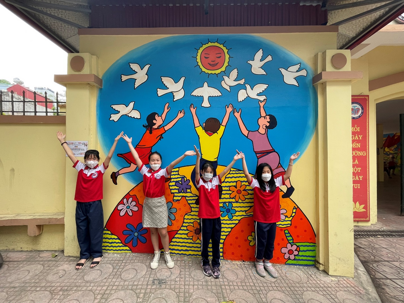 A group of people posing for a photo in front of a sign
Description automatically generated with medium confidence