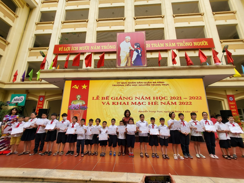 A group of people posing for a photo in front of a building

Description automatically generated