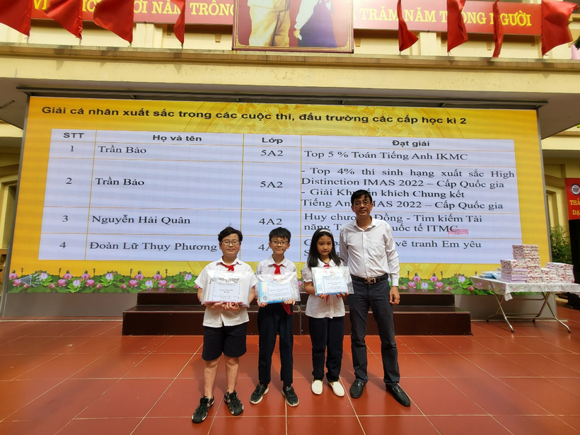 A group of people posing for a photo in front of a large sign

Description automatically generated with medium confidence