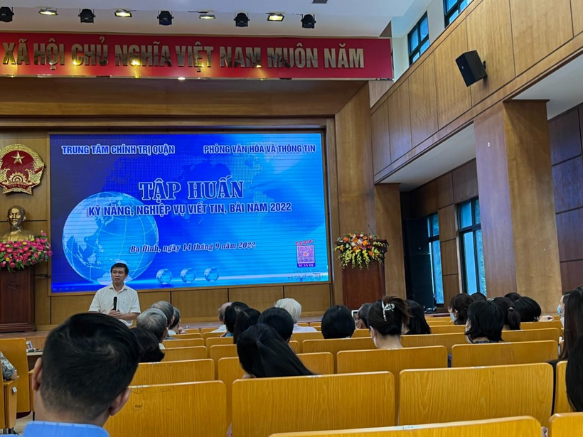 A group of people sitting in a room with a large screen
Description automatically generated with low confidence