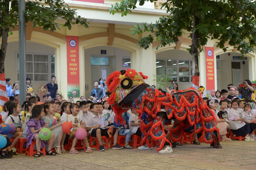 A group of people sitting on the ground in front of a building

Description automatically generated with low confidence