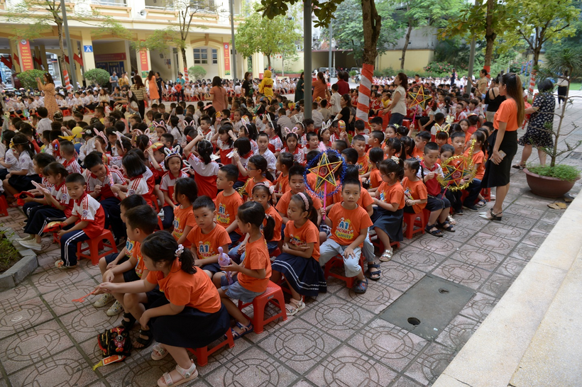 A large group of people sitting on the sidewalk

Description automatically generated with low confidence