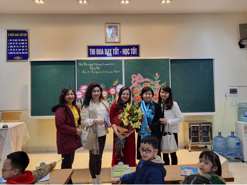 A group of people standing in a classroom

Description automatically generated with medium confidence