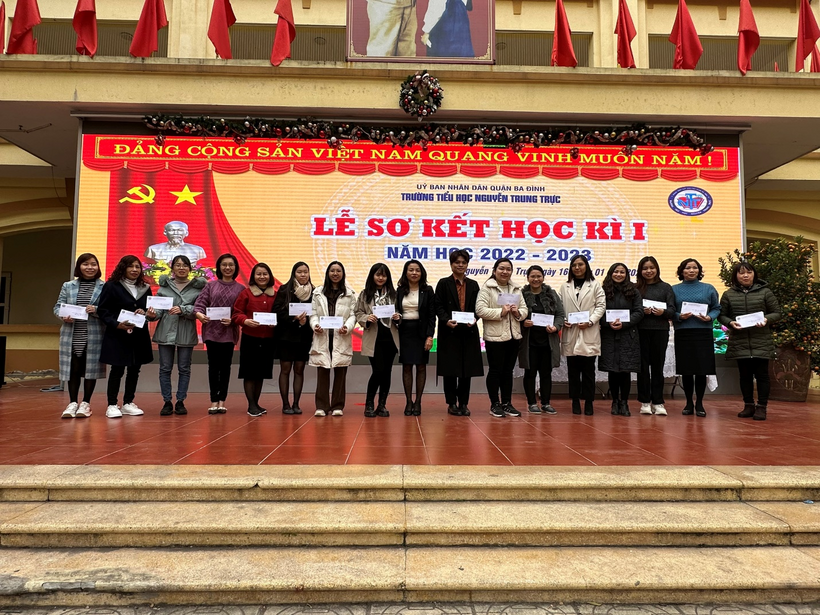 A group of people standing in front of a sign

Description automatically generated with medium confidence