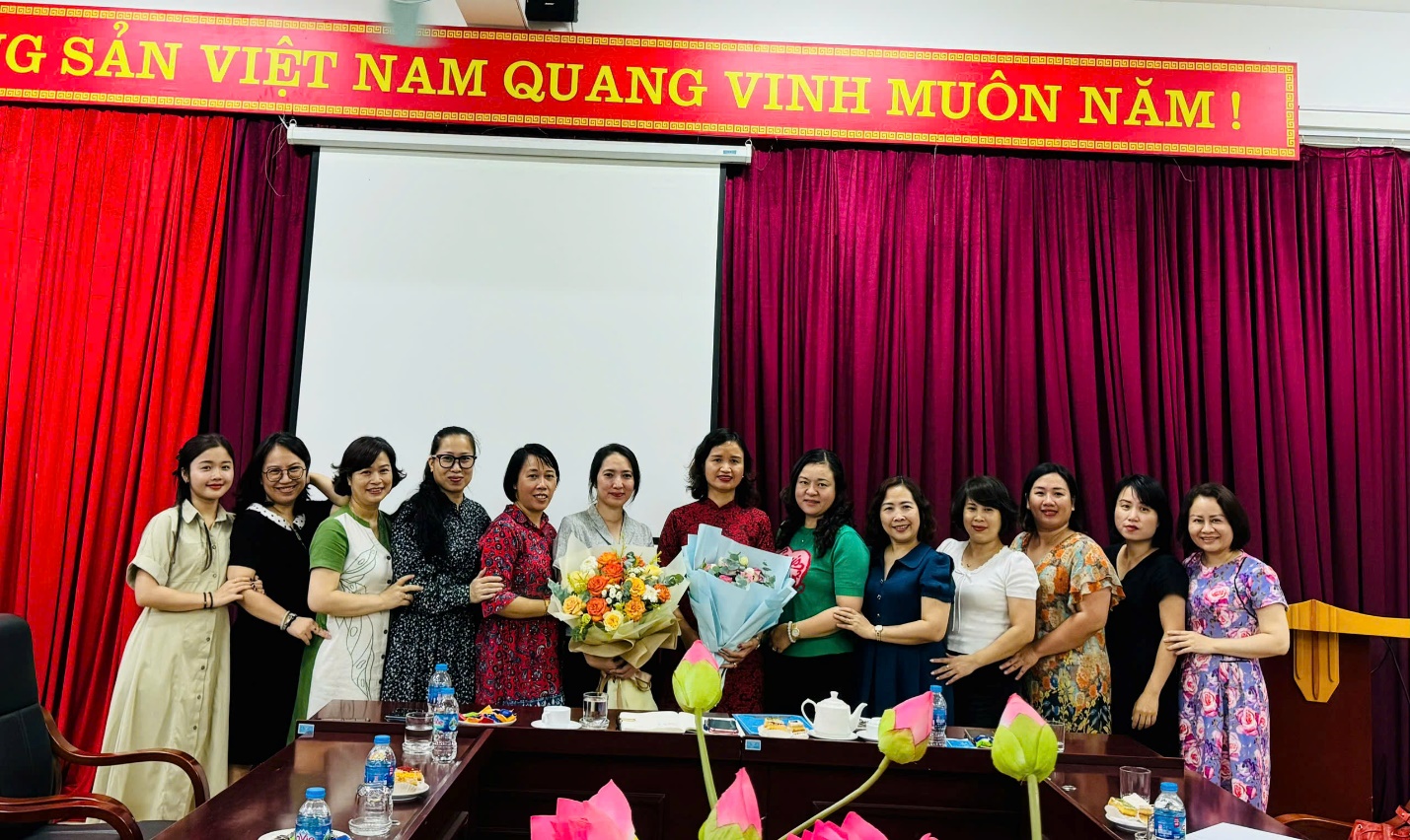 A group of women standing in front of a red curtain

Description automatically generated