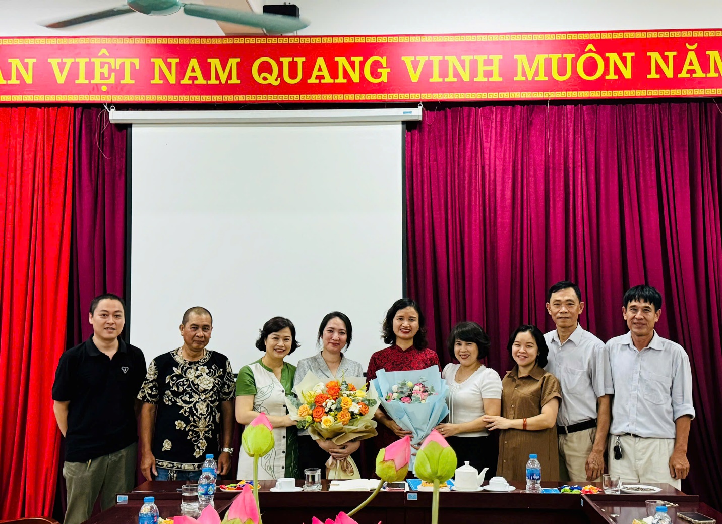 A group of people standing in front of a stage

Description automatically generated