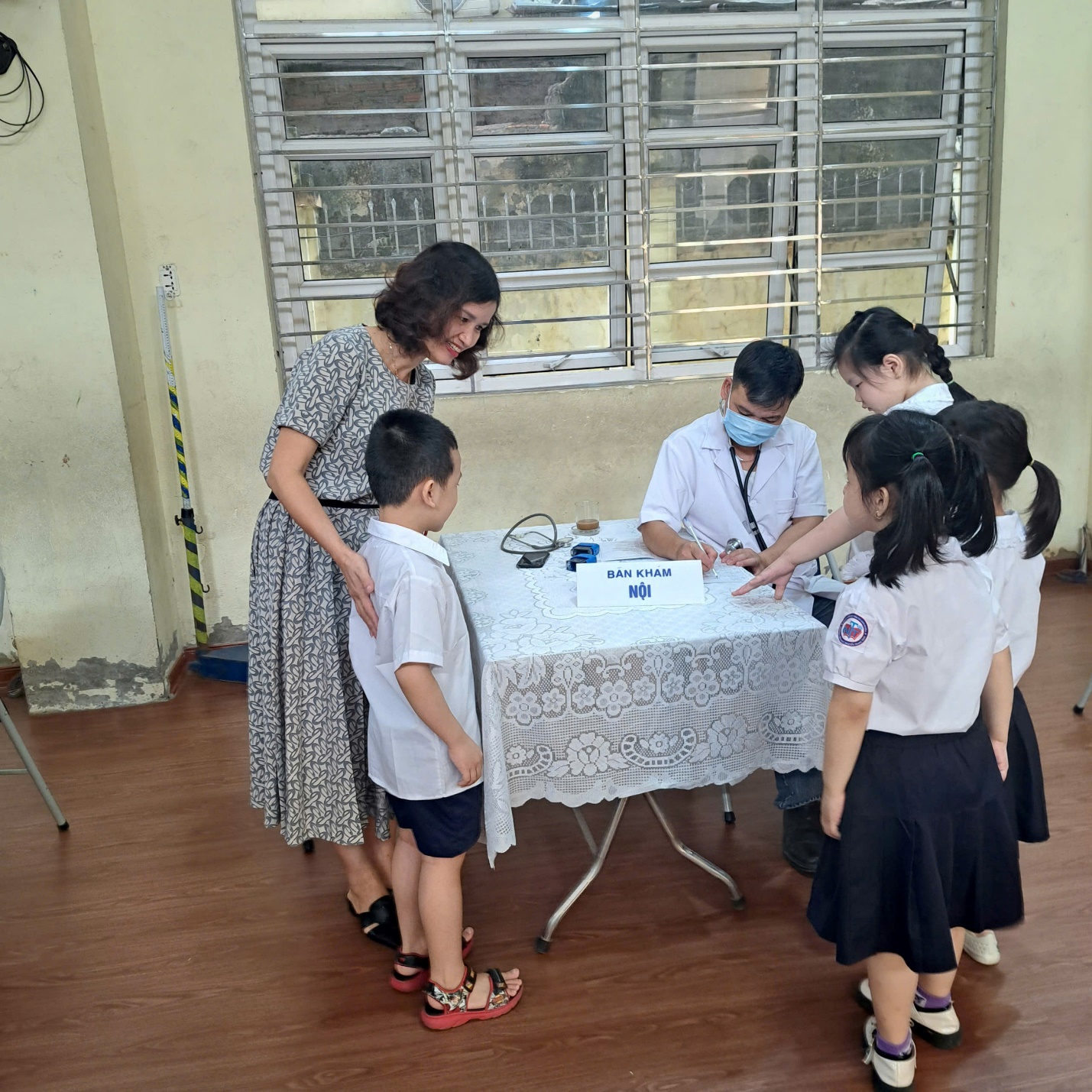 A group of people standing around a table

Description automatically generated