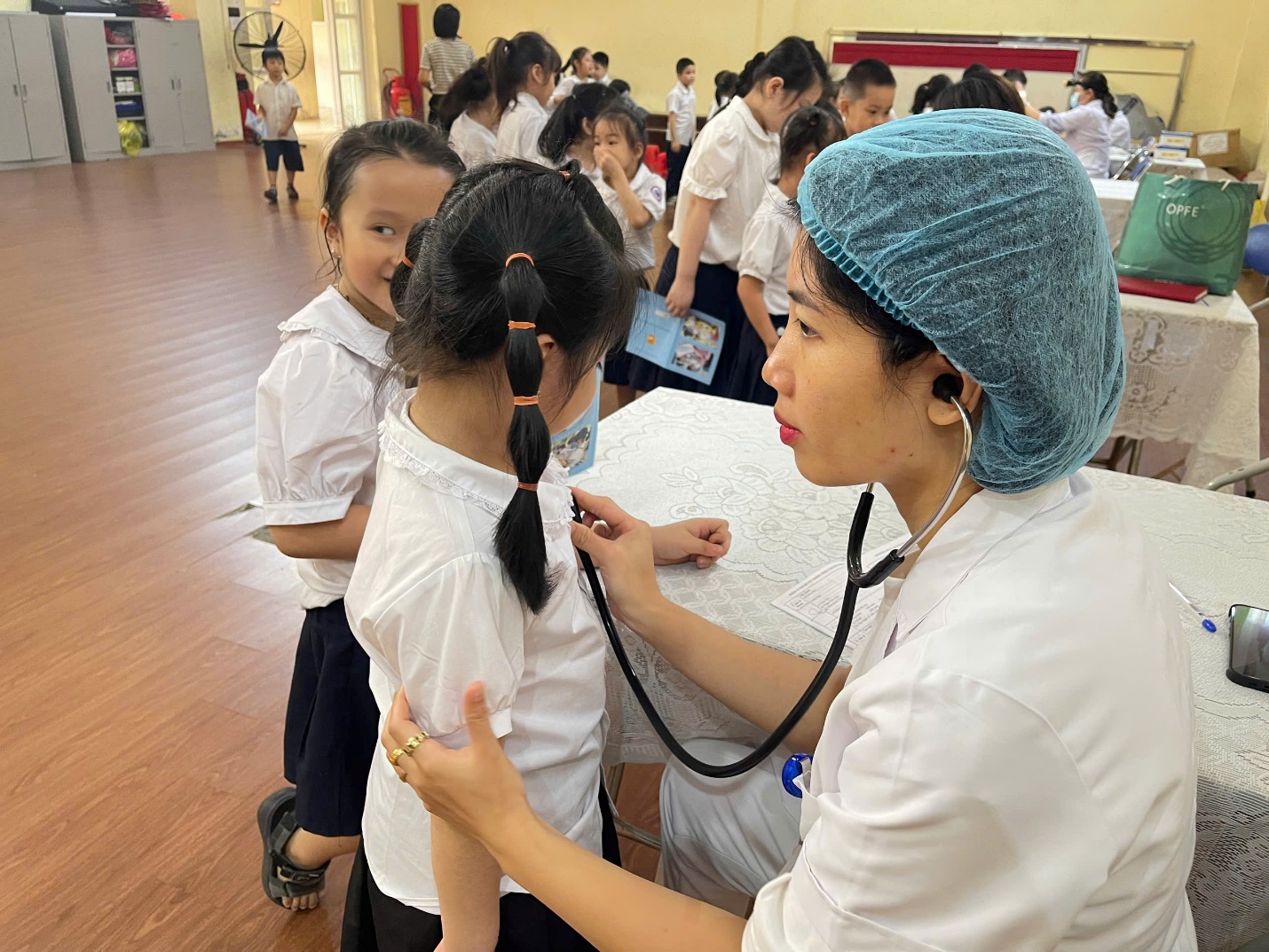 A person listening to a child's heartbeat

Description automatically generated