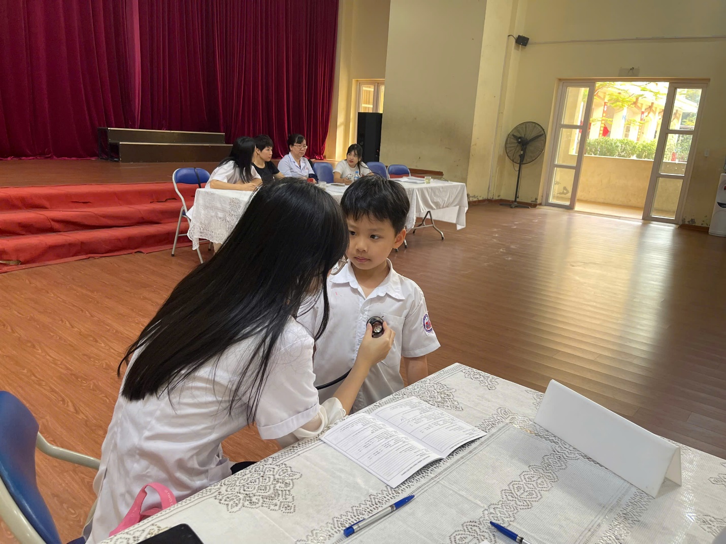 A person and a child sitting at a table

Description automatically generated