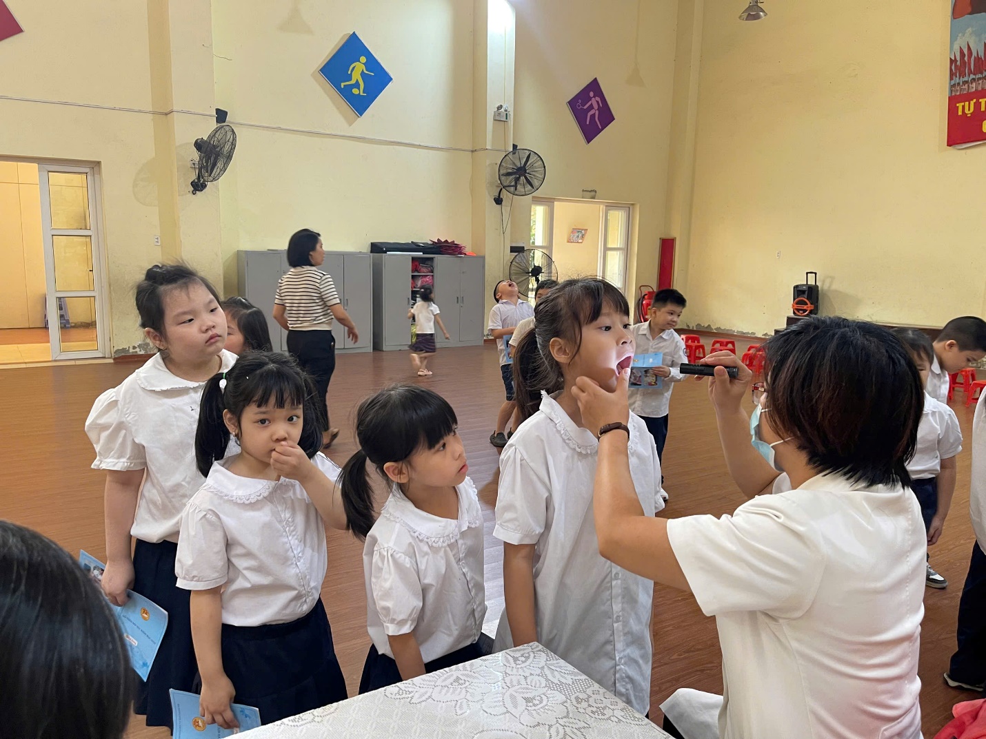 A person brushing her teeth in a classroom

Description automatically generated