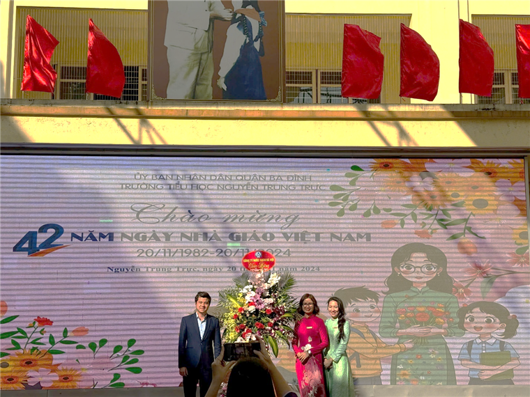 A group of people standing in front of a large sign

Description automatically generated