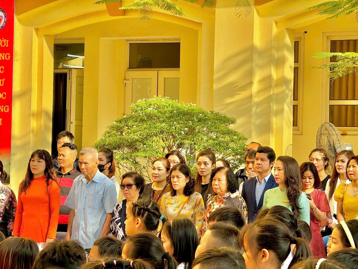 A group of people standing in front of a building

Description automatically generated