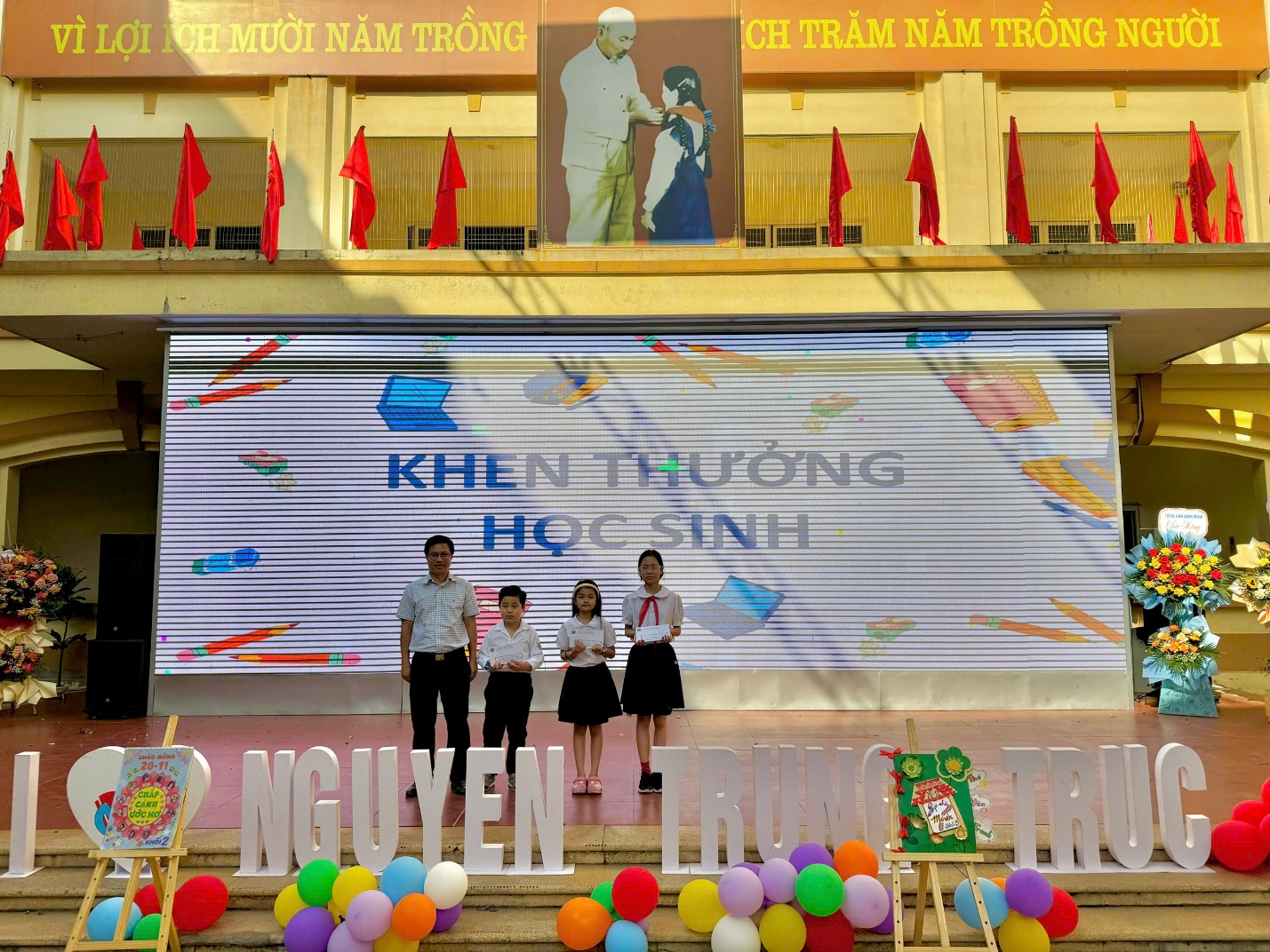 A group of people standing on a stage

Description automatically generated