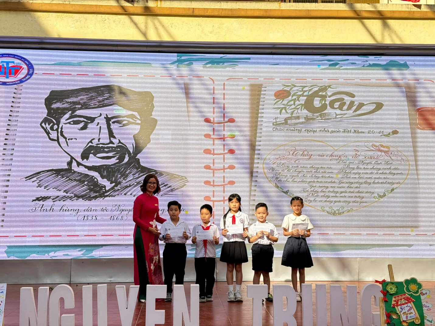 A group of children standing in front of a large sign

Description automatically generated