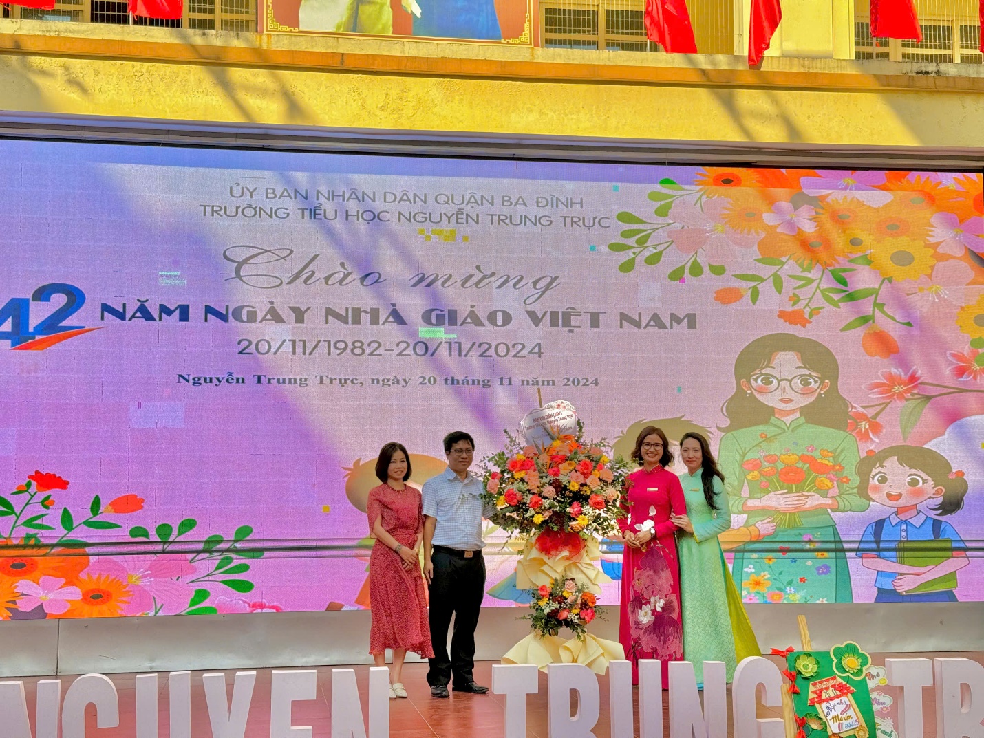 A group of people standing on a stage

Description automatically generated