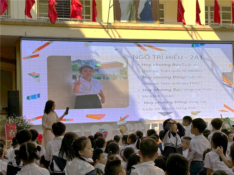 A group of children in front of a large screen

Description automatically generated