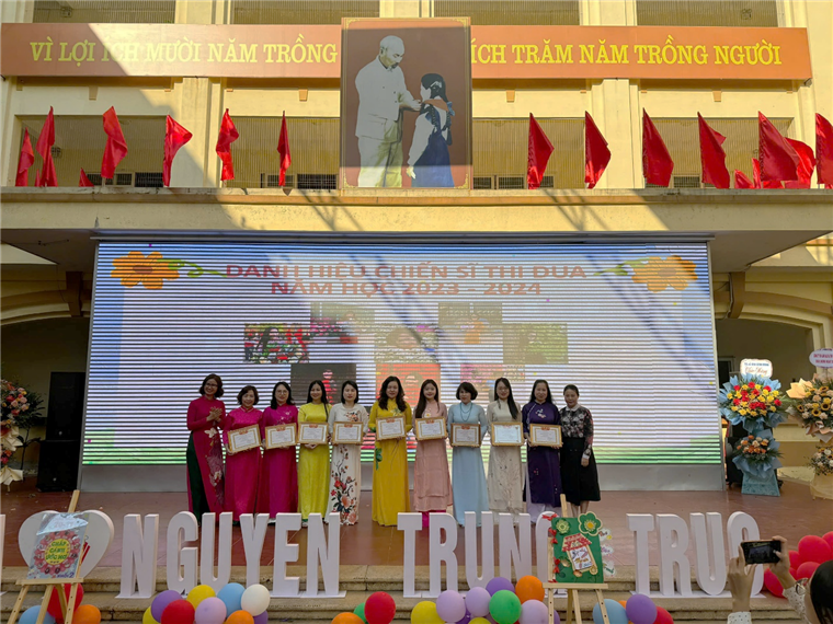 A group of people standing on a stage

Description automatically generated