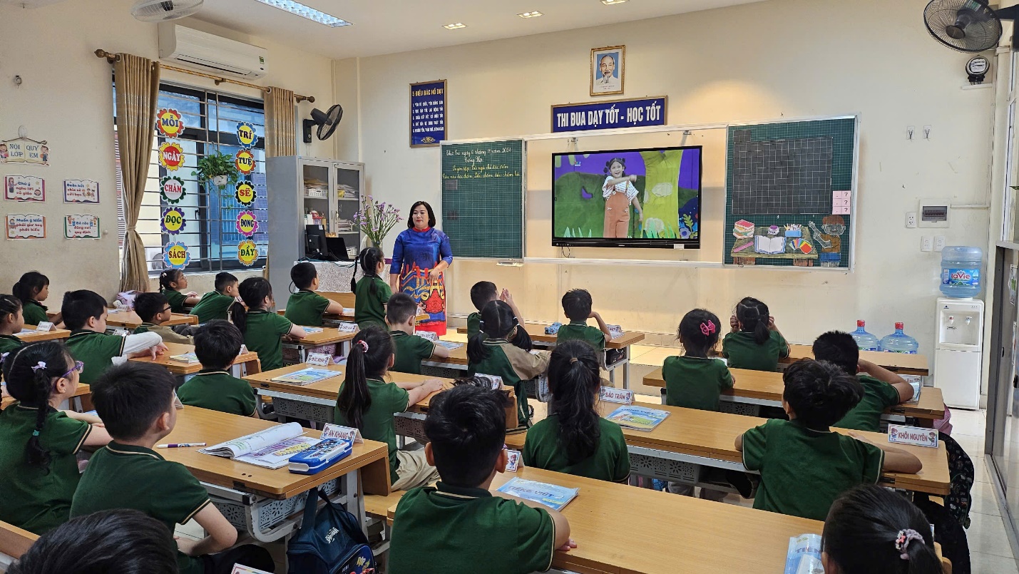 A classroom with a teacher teaching a group of students
Description automatically generated