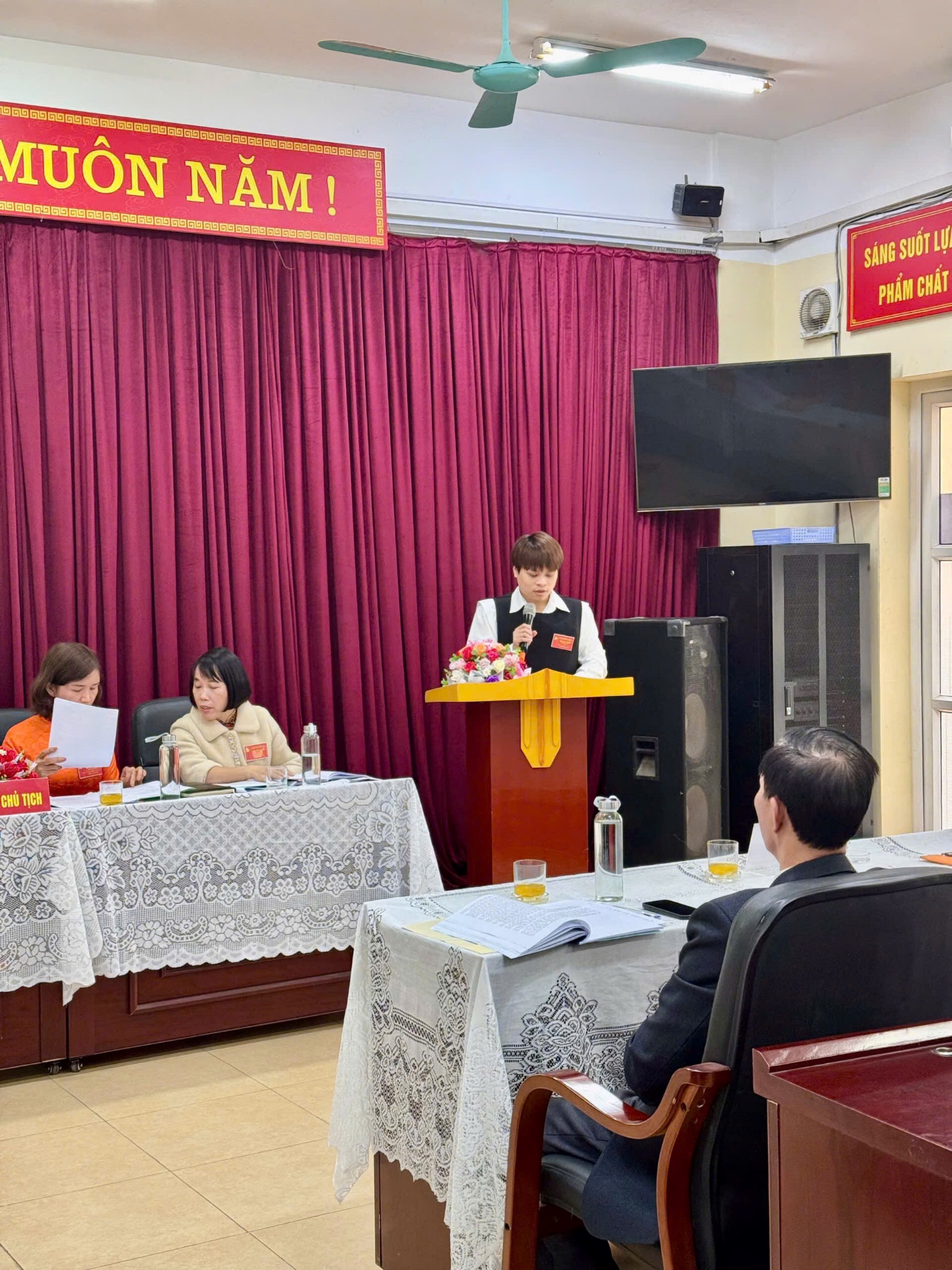 A group of people sitting at tables in a room
Description automatically generated