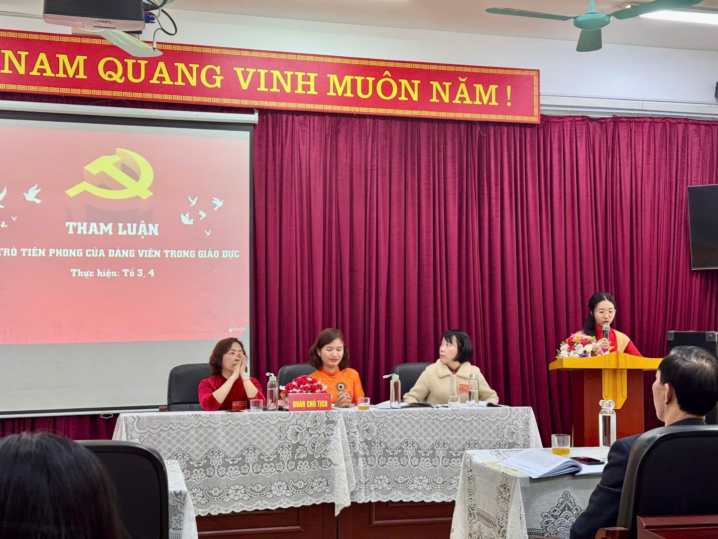 A group of people sitting at a podium
Description automatically generated