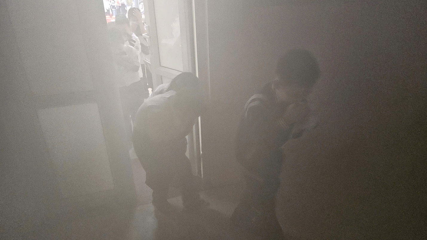 A group of people standing in a dark room

Description automatically generated