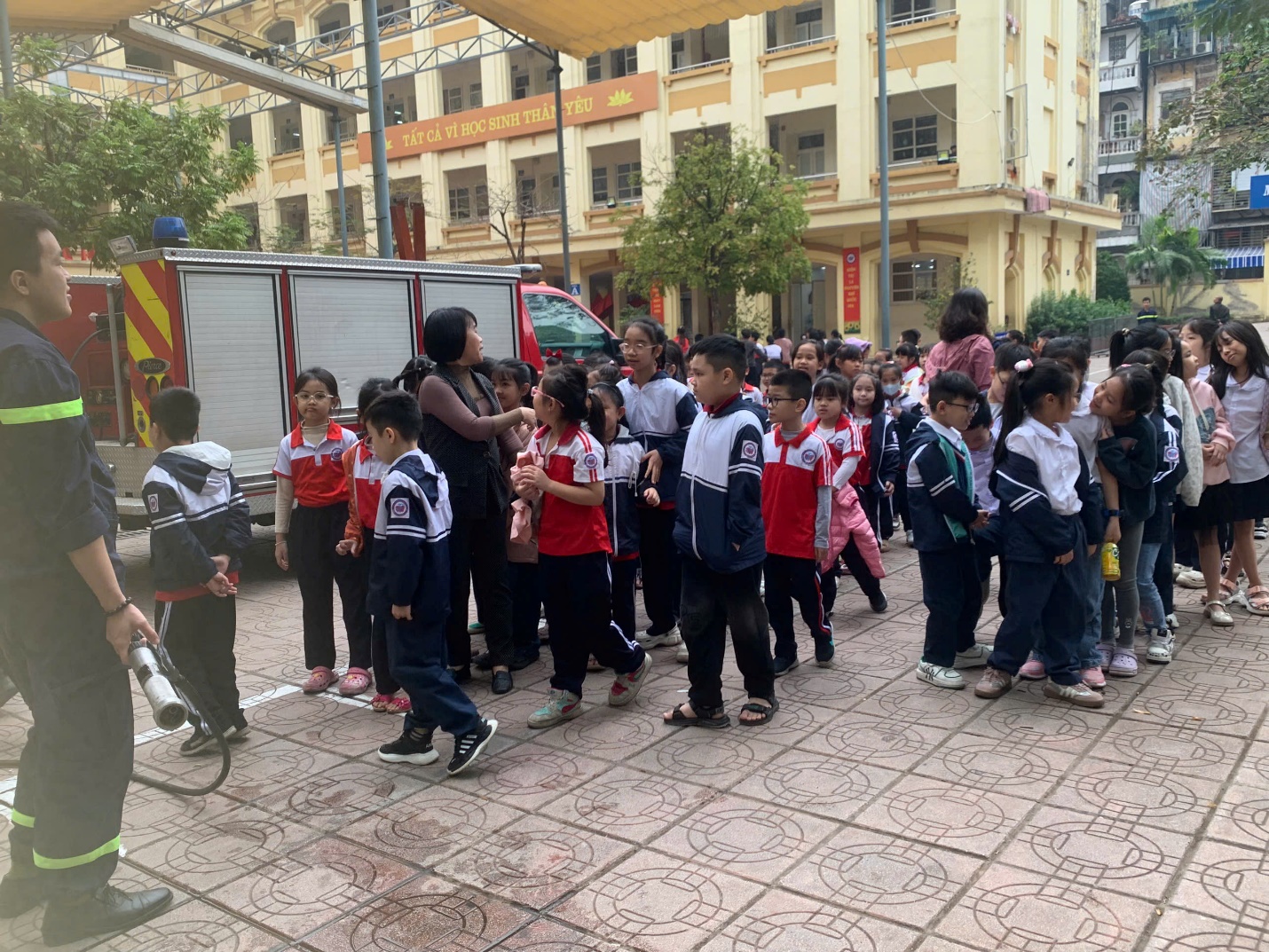 A group of children standing in a line with Buekorps Museum in the background

Description automatically generated