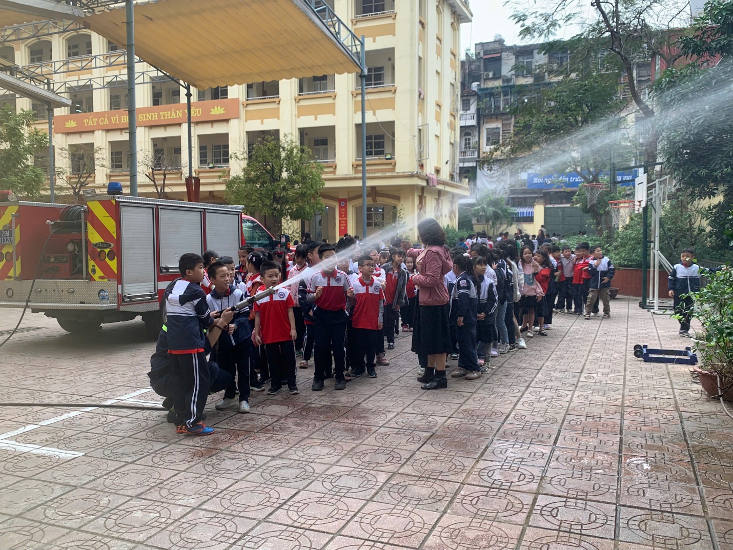 A group of people spraying water on a sidewalk

Description automatically generated