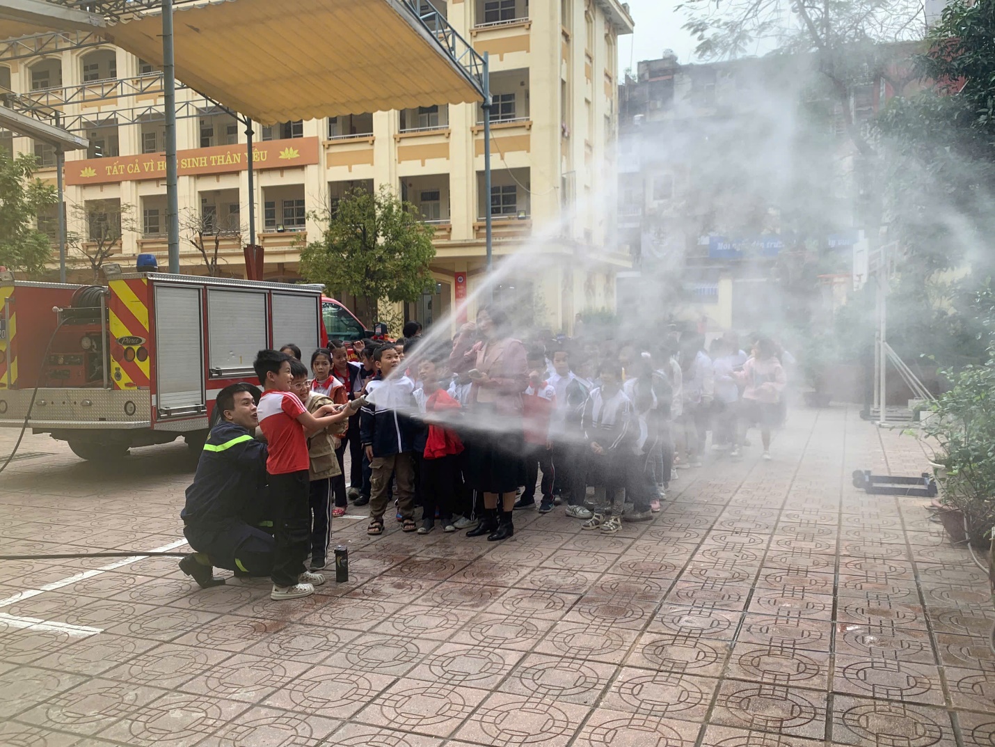 A group of people spraying water on a street

Description automatically generated