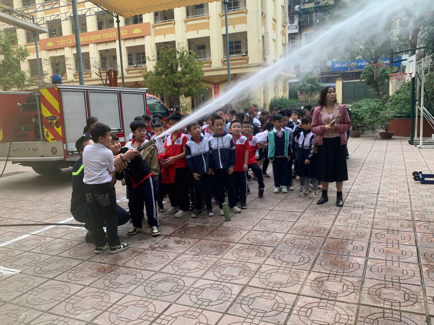 A group of children spraying water on their faces

Description automatically generated