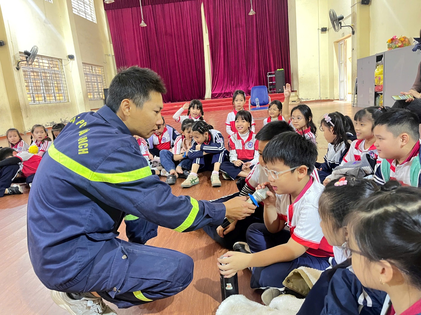 A person in a uniform holding a hand on a group of children

Description automatically generated