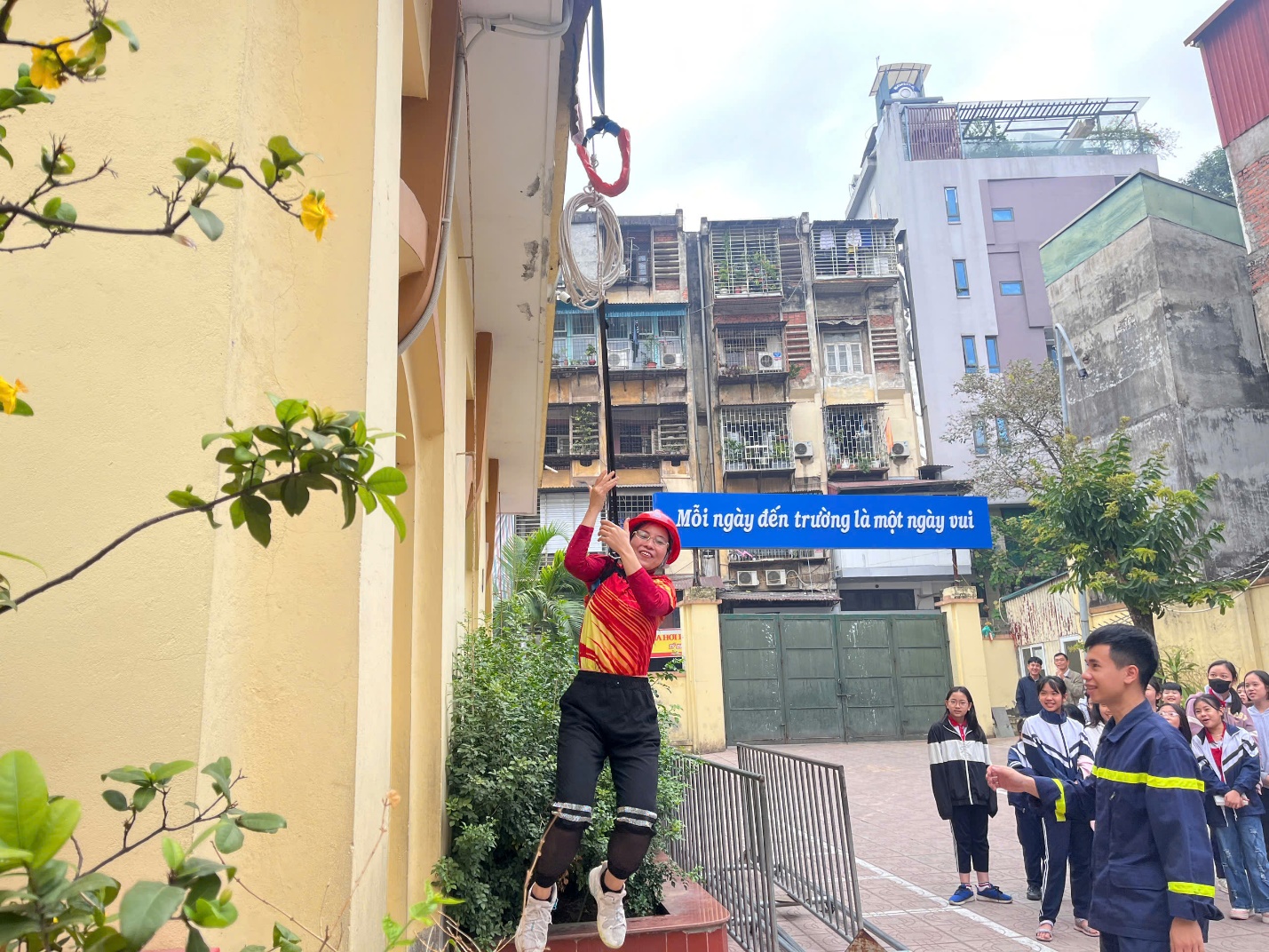 A person in a red helmet from a building

Description automatically generated