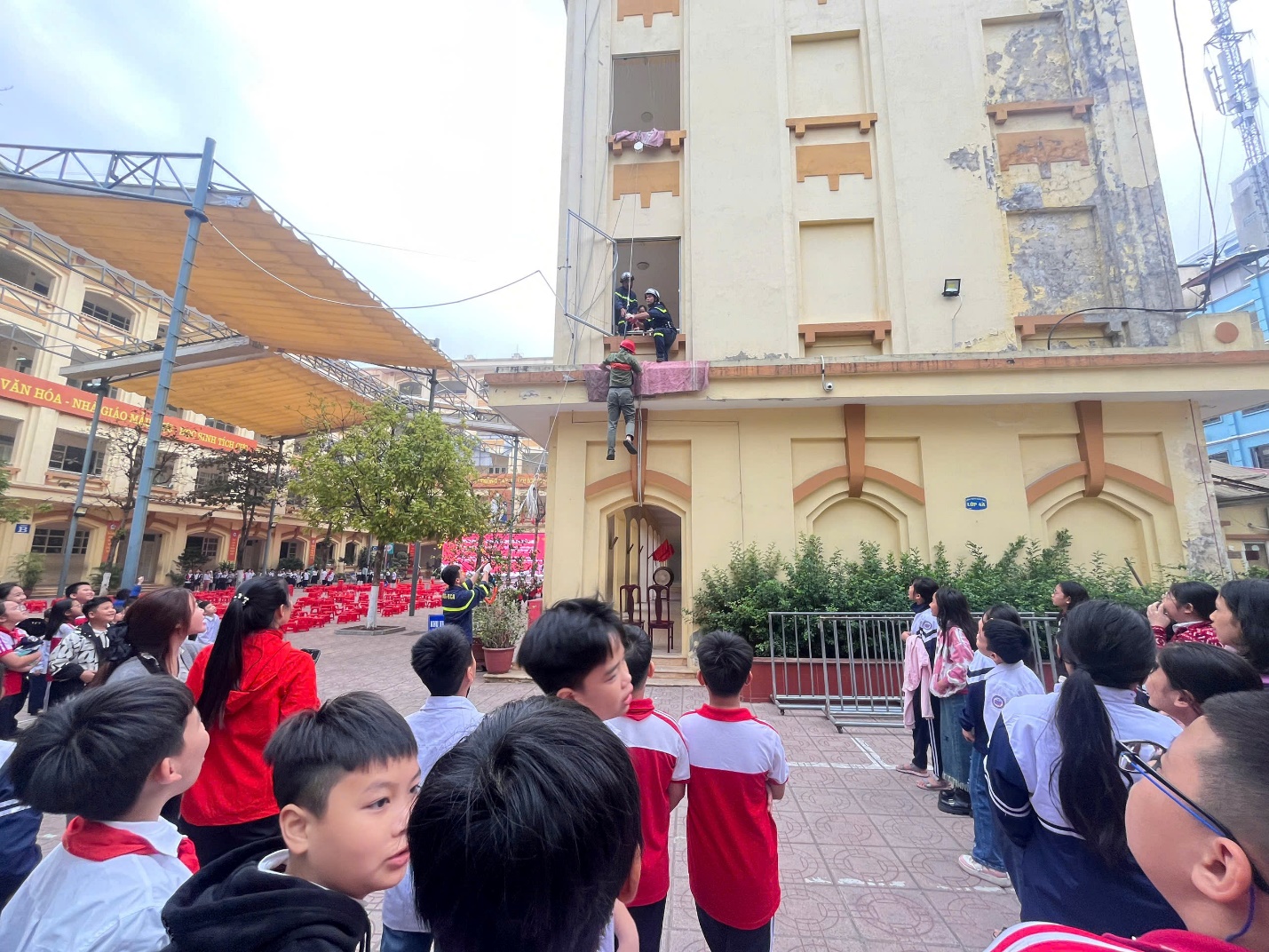 A group of children standing in front of a building

Description automatically generated