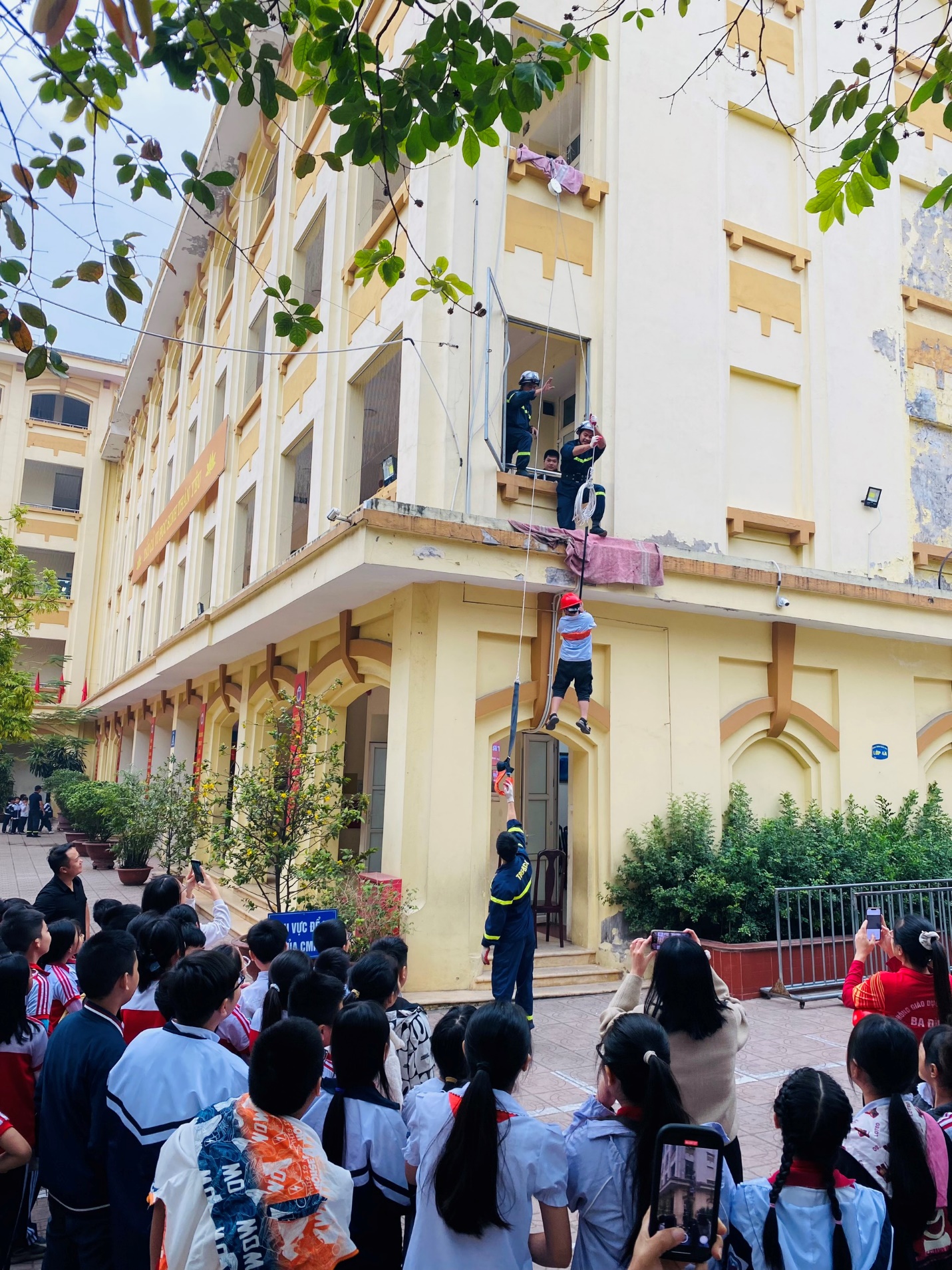 A group of people standing on a building

Description automatically generated
