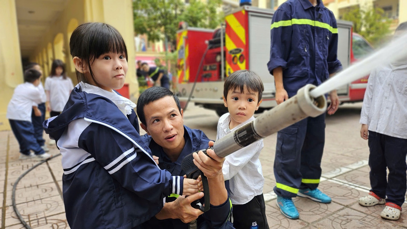 A group of people holding a hose

Description automatically generated