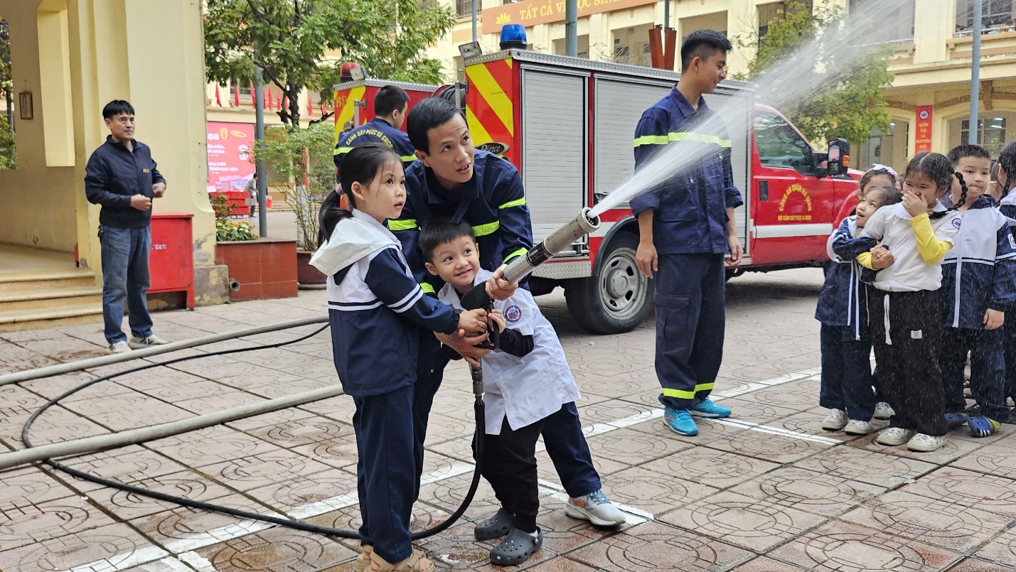 A person and two children holding a hose

Description automatically generated