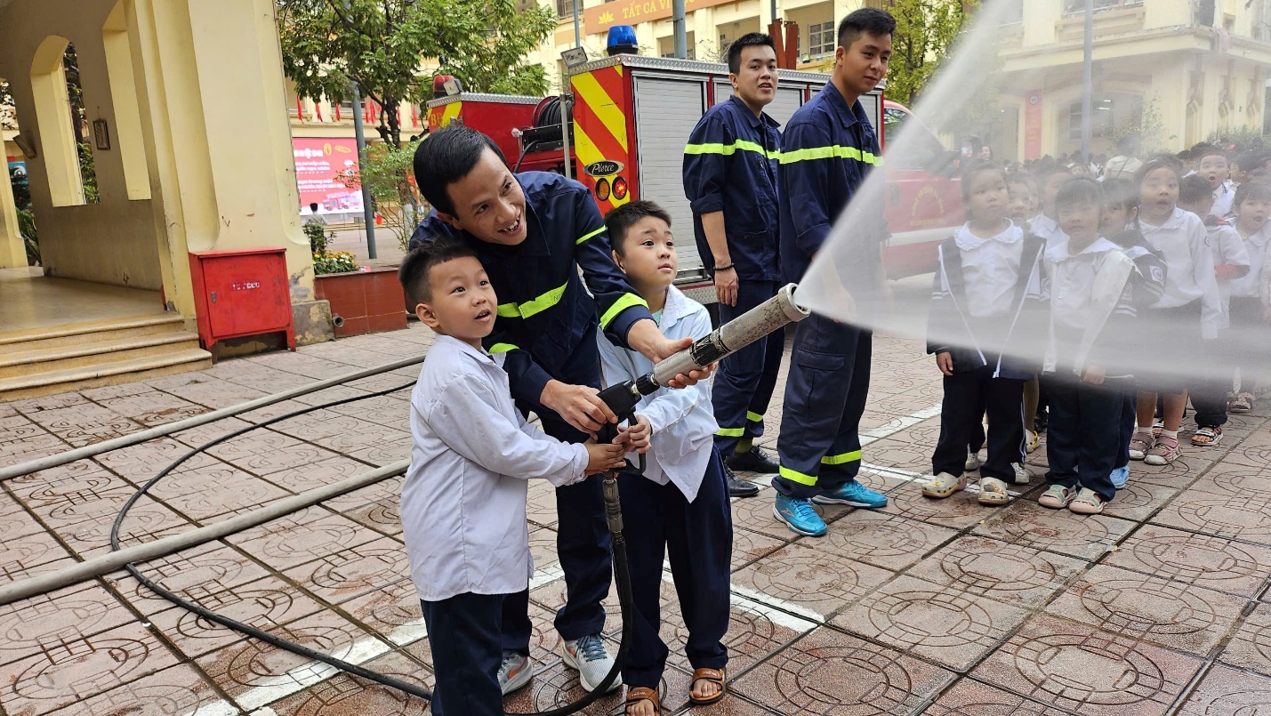 A group of people holding a hose

Description automatically generated