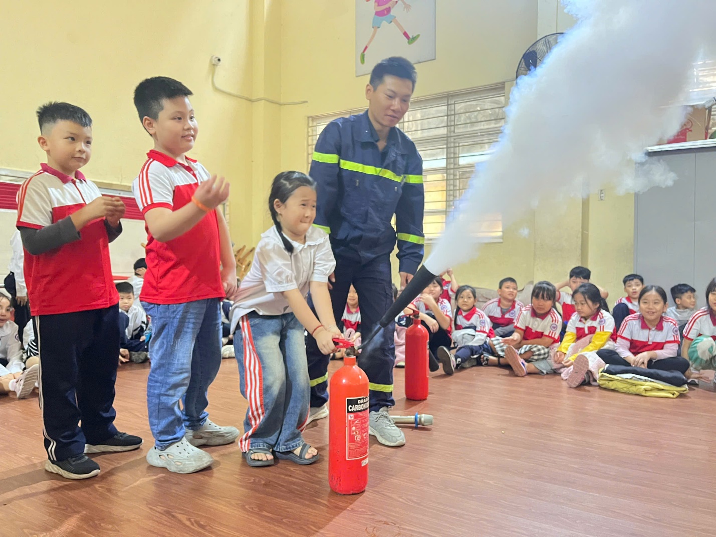 A group of kids in a classroom with a fire extinguisher

Description automatically generated