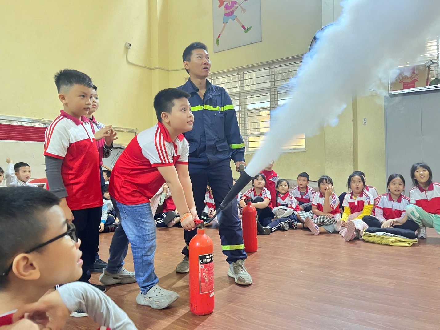 A group of kids in a room with a fire extinguisher

Description automatically generated