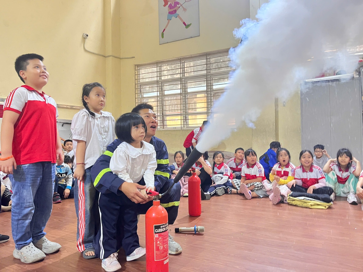 A group of children in a room with a fire extinguisher

Description automatically generated