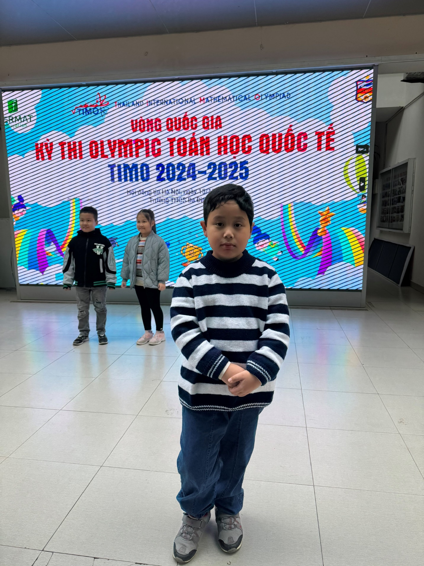 A child standing in front of a large screen

Description automatically generated