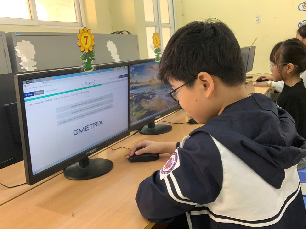 A child sitting at a desk using a computer

Description automatically generated