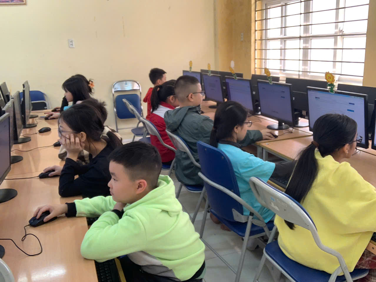 A group of children in a computer lab

Description automatically generated