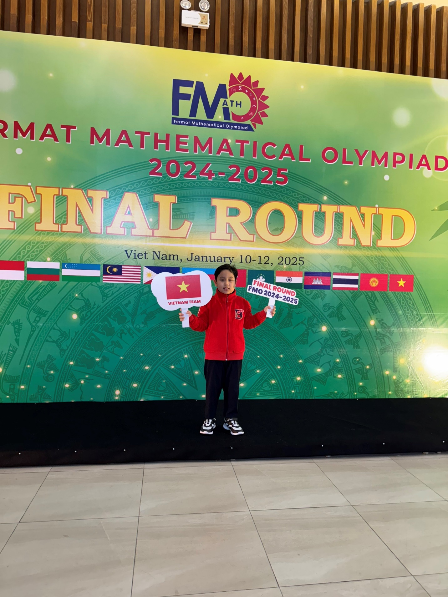 A child standing in front of a banner

Description automatically generated