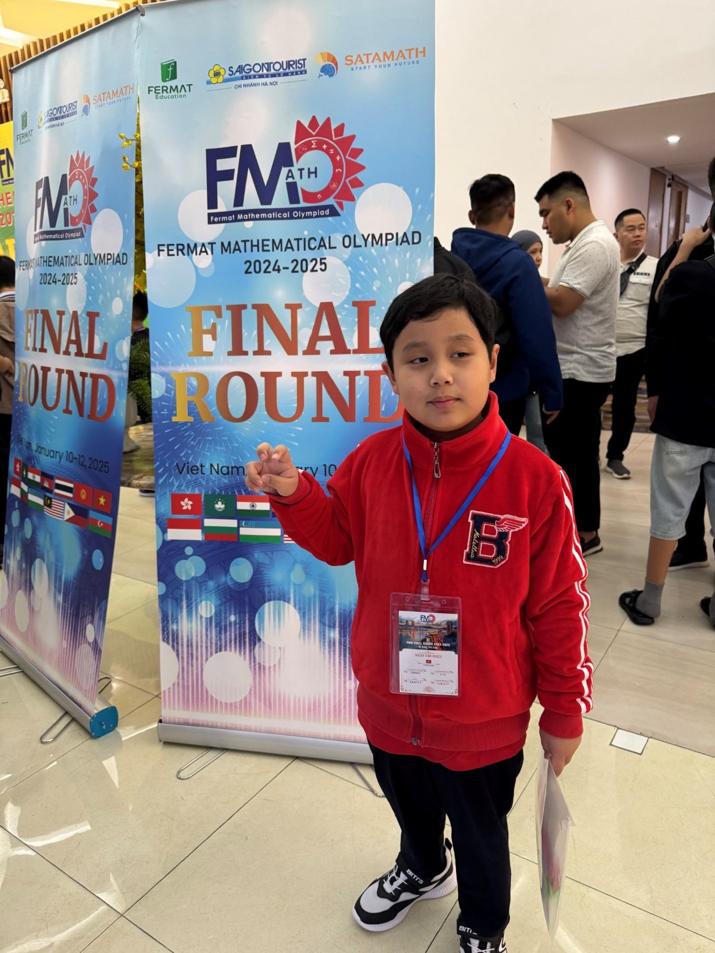 A child standing in front of a banner

Description automatically generated