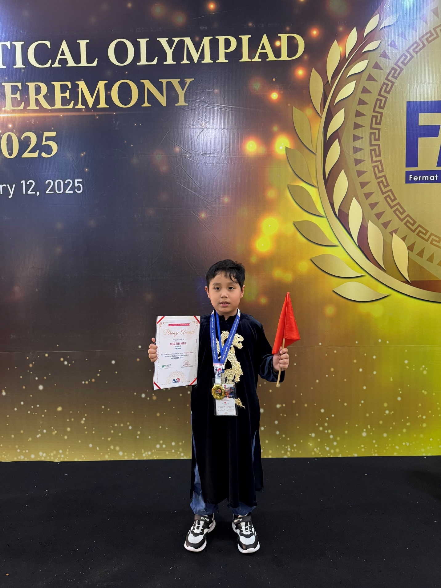 A child holding a certificate and a flag

Description automatically generated