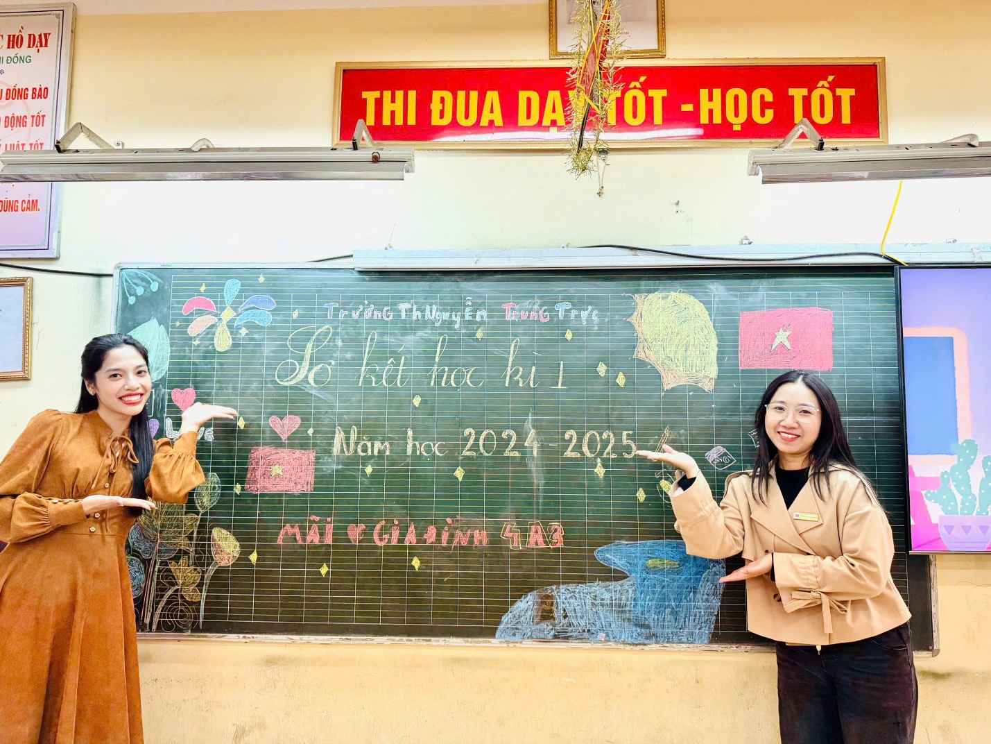 Two women standing in front of a chalkboard

Description automatically generated