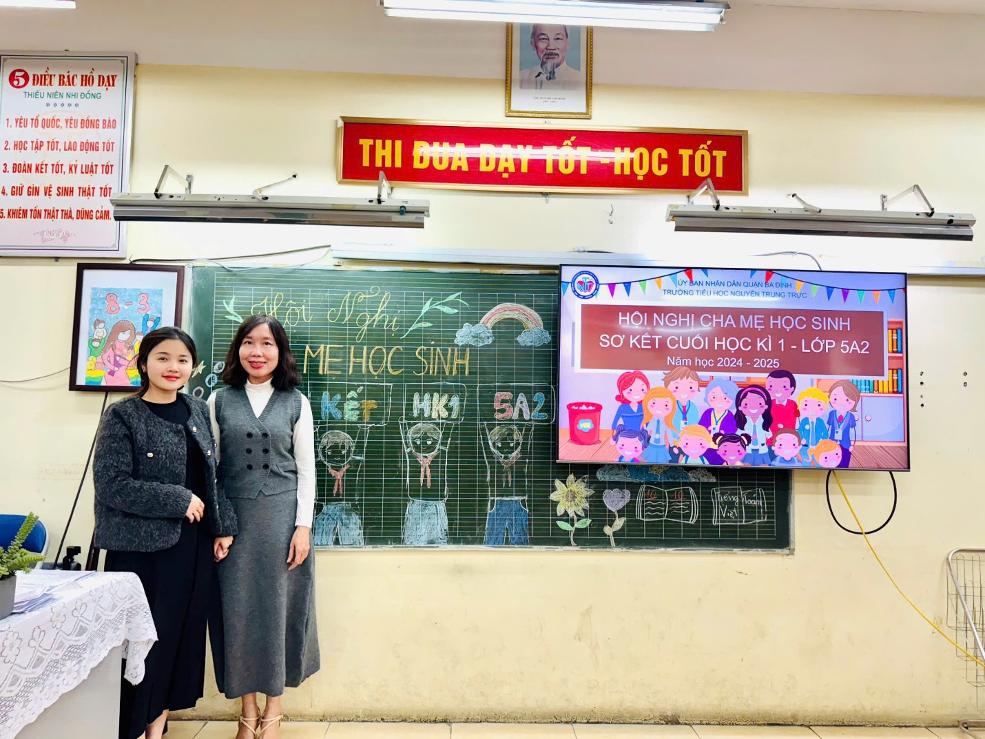 Two women standing in front of a chalkboard

Description automatically generated