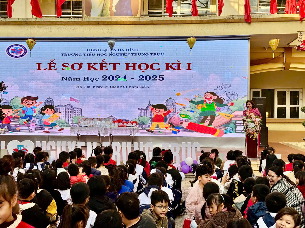 A group of people sitting in front of a large screen

Description automatically generated